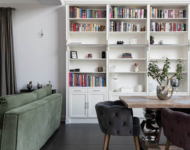 a living dining room with a large bookshelf