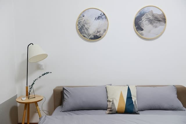 close up on a bed with two circular painting above it