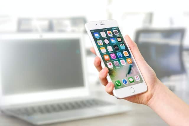 person holding white cellphone with social media apps open