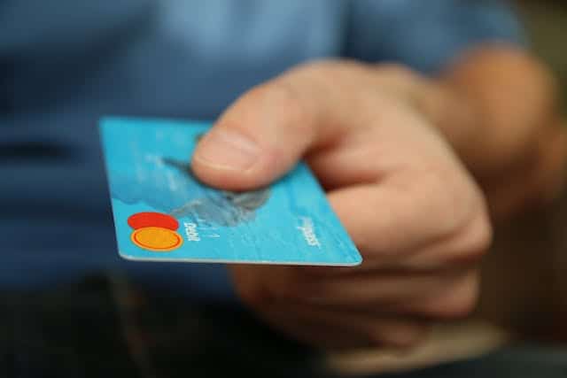 person-holding-out-their-debit-card