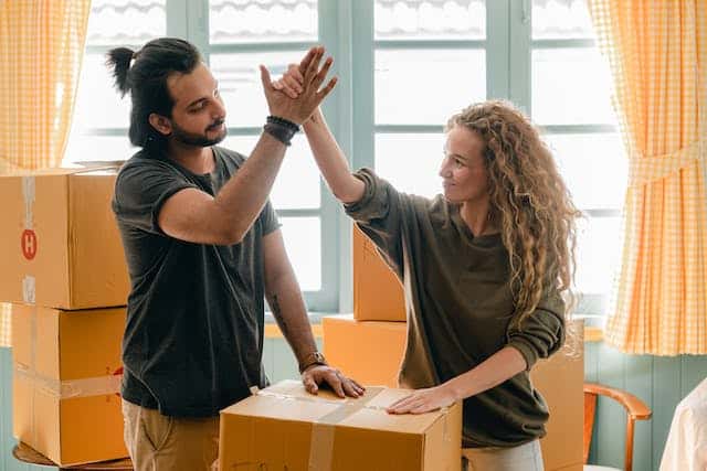 two-people-surrounded-by-moving-boxing-high-fiving