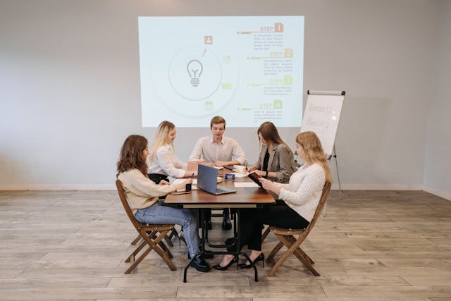 a-group-of-people-having-a-business-meeting-in-a-conference-room-with-a-presentation-on-the-screen