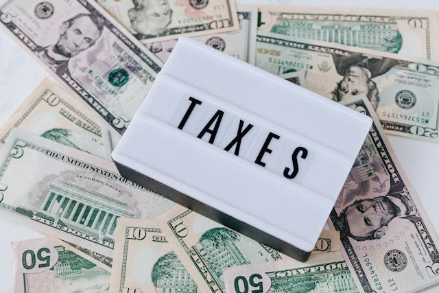lightbox-with-the-word-taxes-placed-on-top-of-scattered-us-dollar-bills