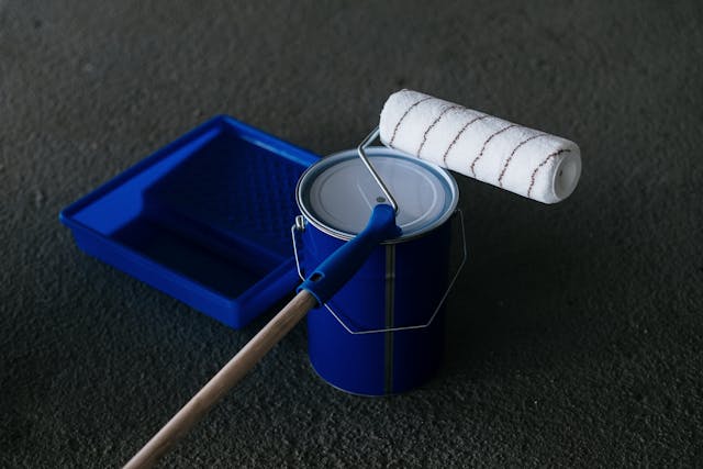 a-paint-bucket-and-roller-on-the-floor