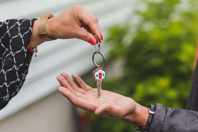 person-handing-house-key-over-to-another-person