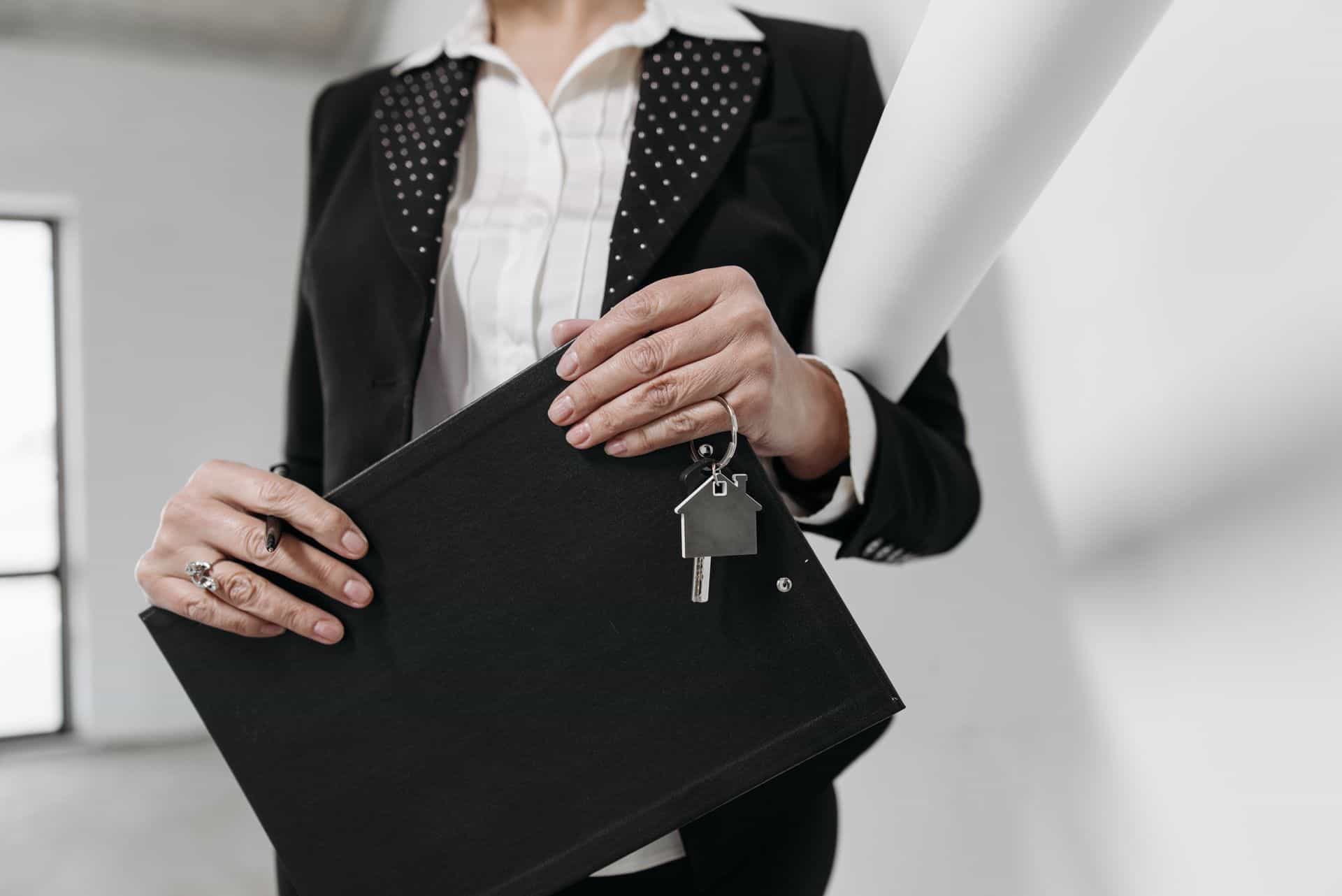 a person holding a folder and house keys
